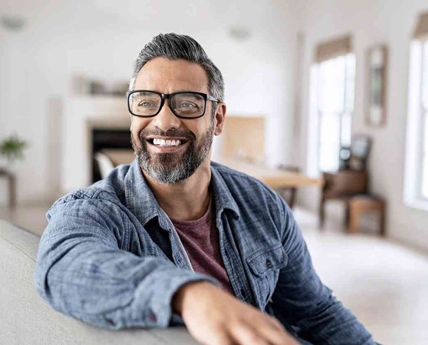 man sitting on couch smiling